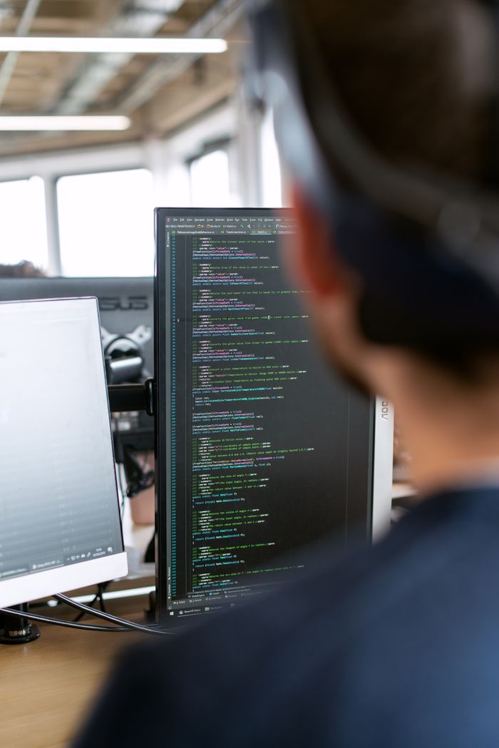team-02 A male software engineer working on code in a modern office setting.